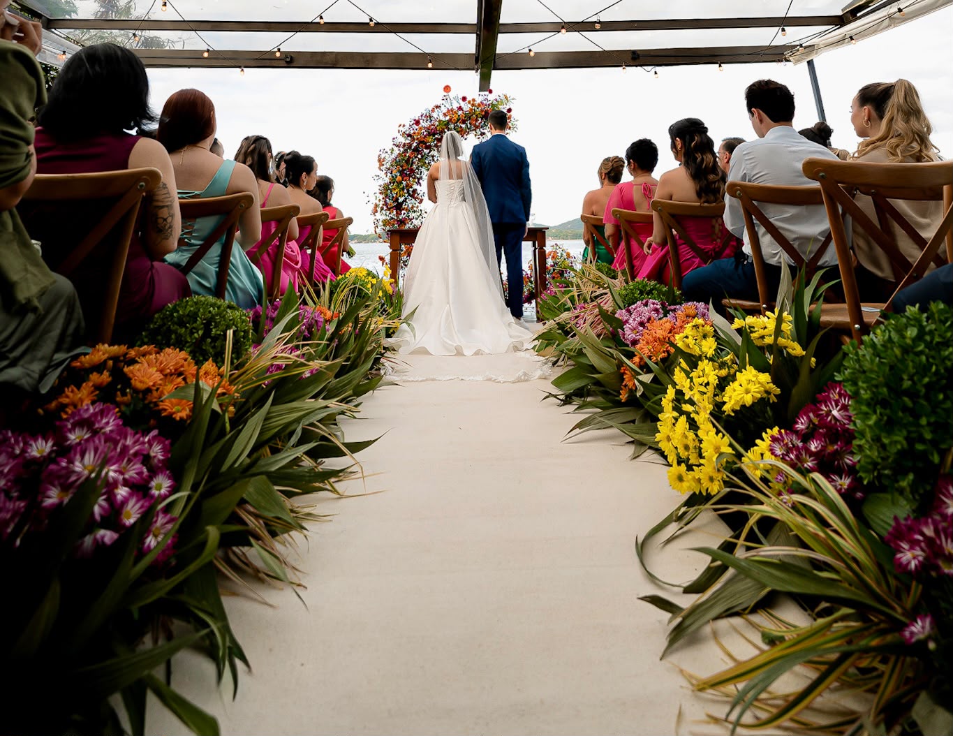 Cerimônia de casamento com aisle florido colorido e noiva ao altar